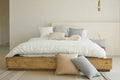 Aria solid oak platform bed in a warm minimalist bedroom