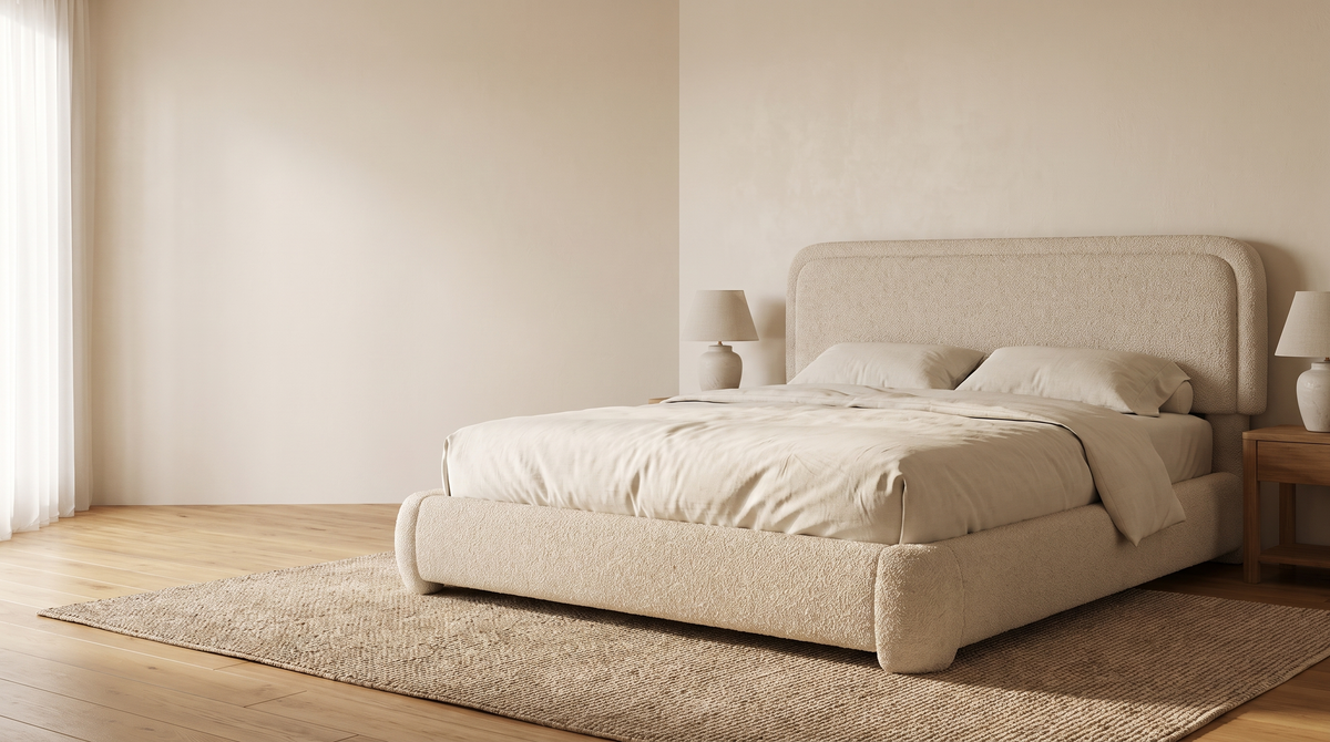 Beige Sora boucle bed in a sunlit bedroom with cream bedding and oak furniture